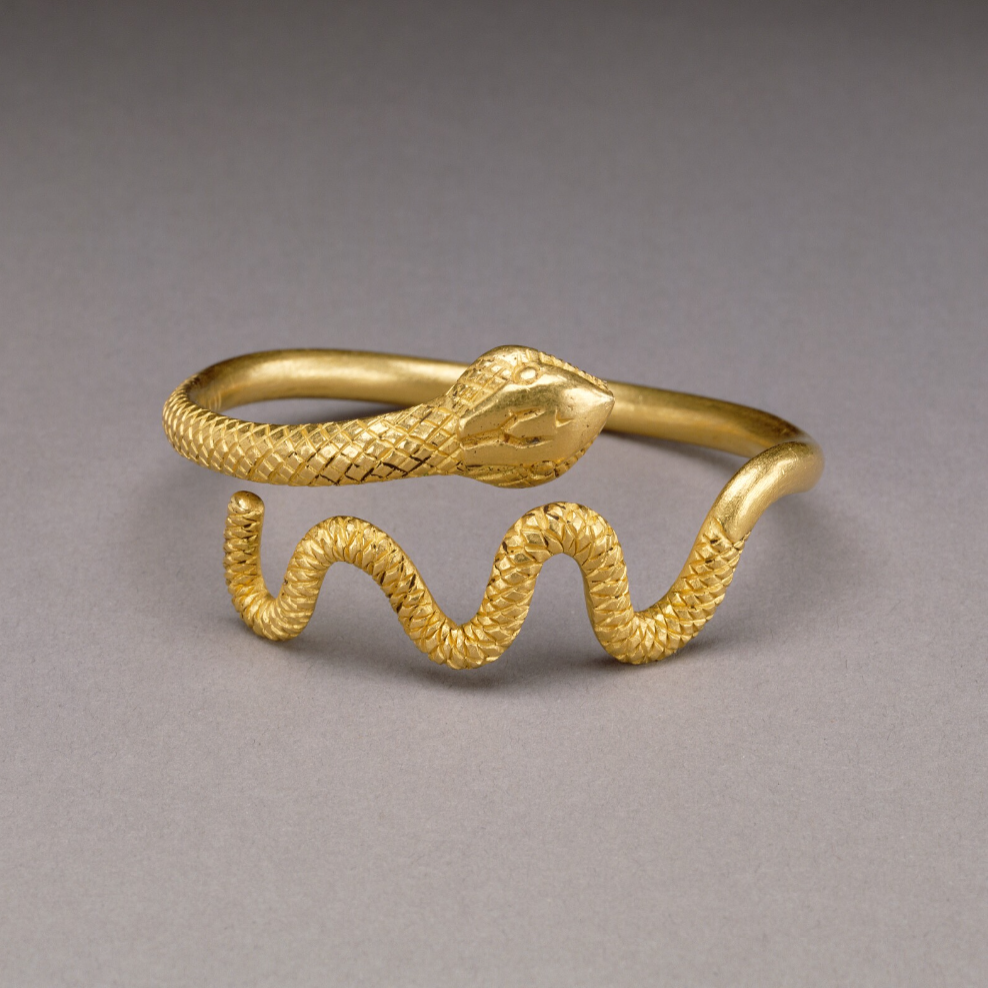 Gold snake-shaped ring on a white background