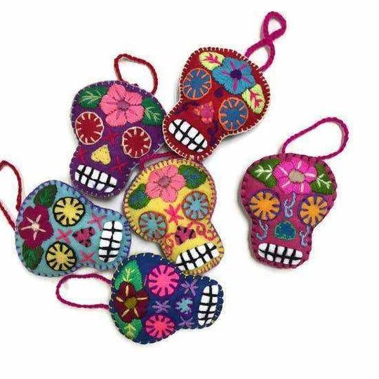 Colorful skull-shaped decorations with floral patterns on a white background