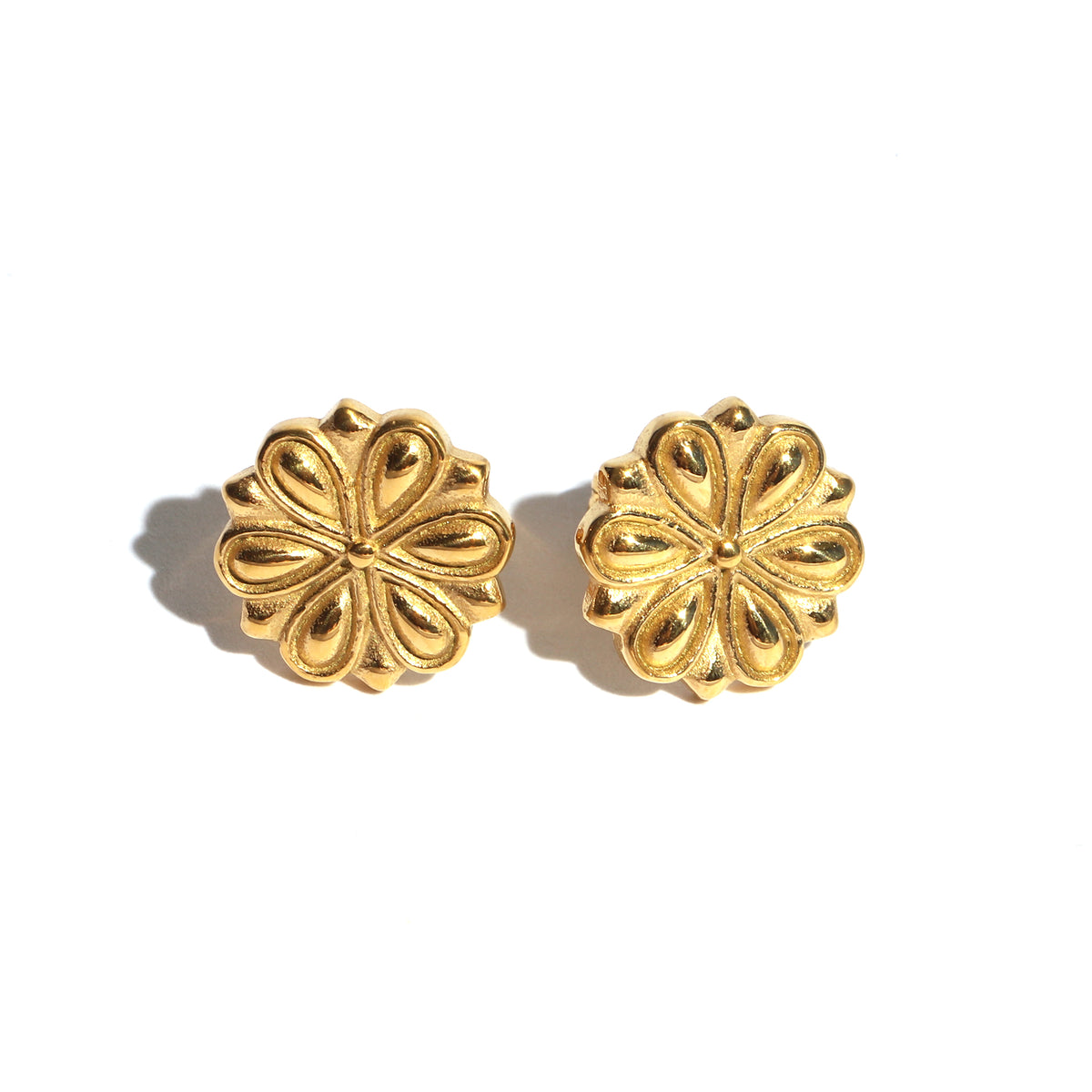 Pair of gold floral earrings on a white background