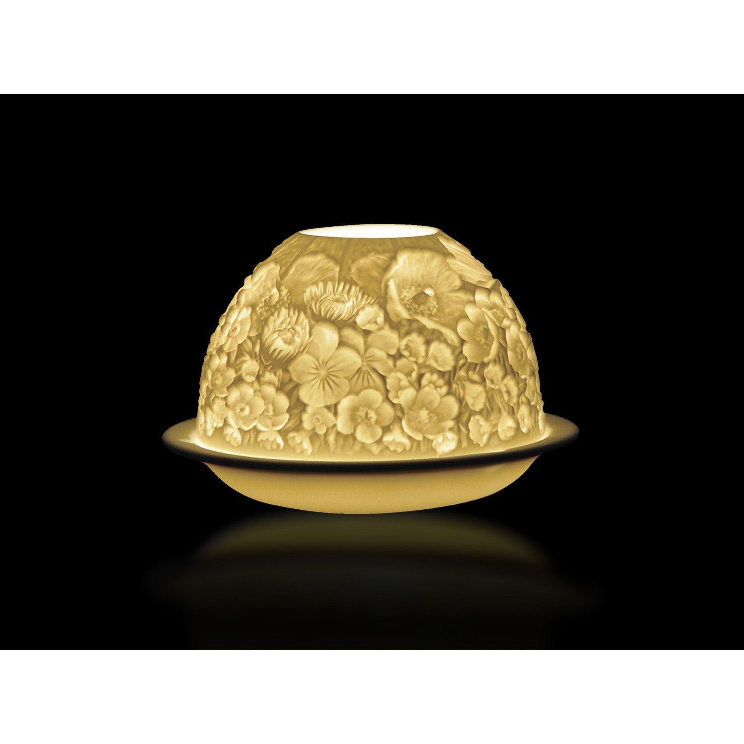 A porcelain votive with floral engraving, illuminated from the inside to highlight the detailed floral pattern.