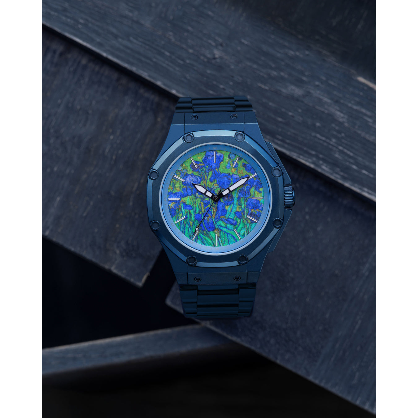 A stainless steel blue watch face featuring a pattern of irises, with a matching blue steel band.