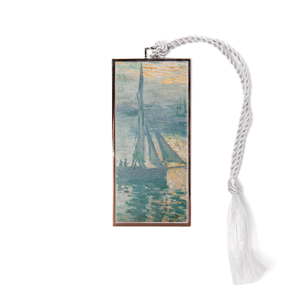 A metal bookmark with a gold finish, featuring a printed reproduction of Claude Monet's painting 'Sunrise (Marine)', with a white tassel.