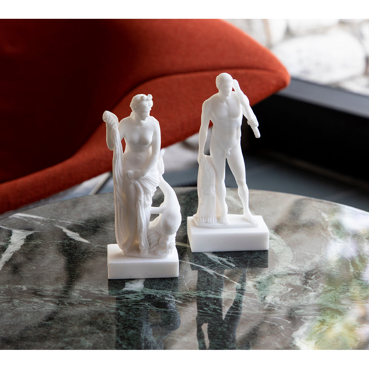 A white statue of Venus with a dolphin at her feet, representing the goddess of love from Roman and Greek mythology.