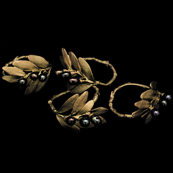 A napkin ring featuring a bronze-colored leaf-like design with black accents, displayed against a white background.