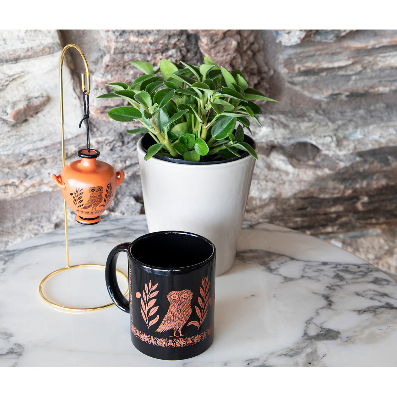 A black porcelain mug with a red Athenian owl and olive branch design.