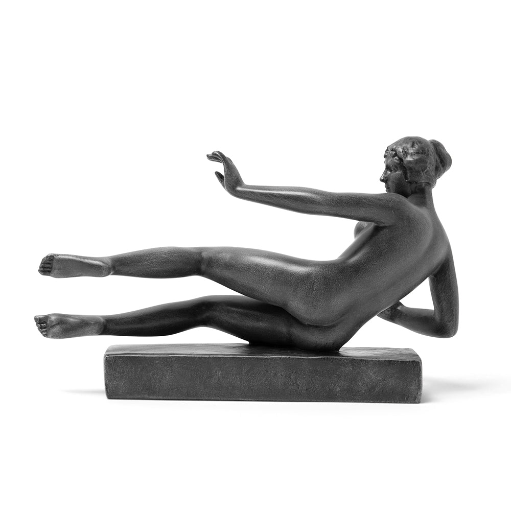 A black sculpture reproduction of Aristide Maillol's L'Air, depicting a nude female figure in a dynamic pose, resting on an imaginary center of gravity.